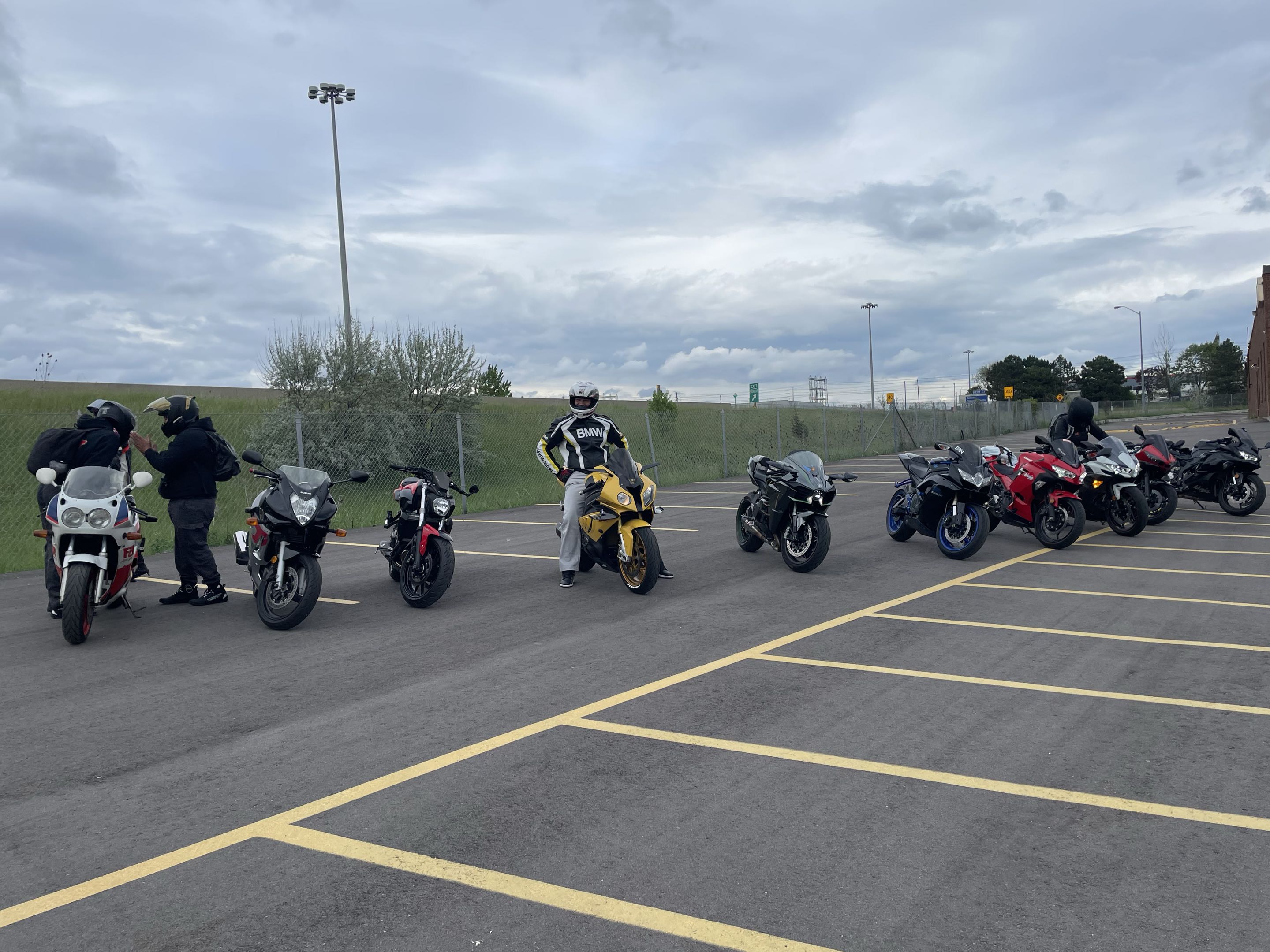 Wide row of motorcycles lined up in parking lot
