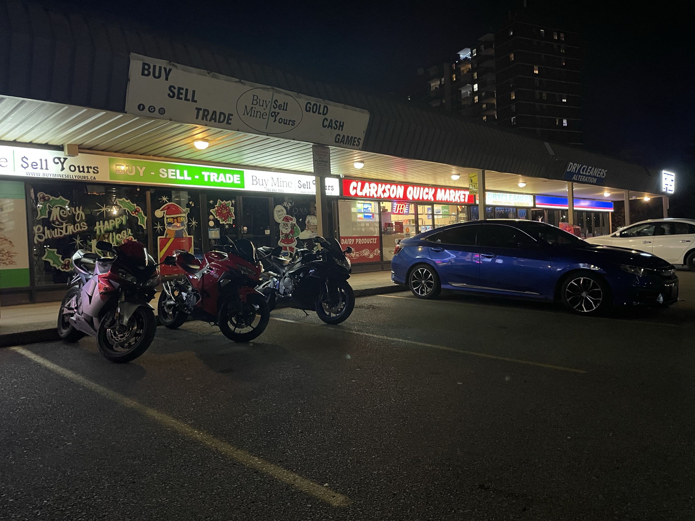 Motorcycles and cars lined up at a night meetup